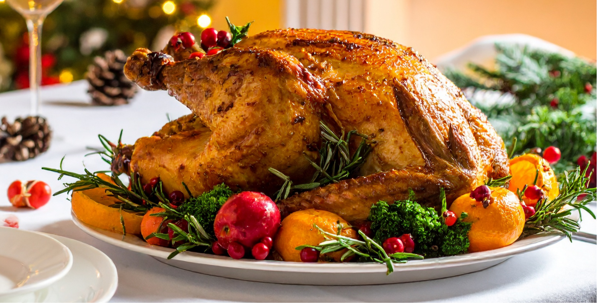 Christmas Turkey on a table on a plate with coloured vegetables around ie